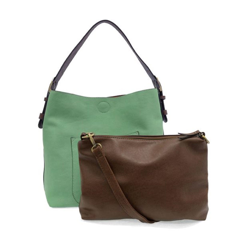 A mint green tote bag with a dark handle stands behind a brown crossbody bag with a matching strap, both made of leather or faux leather, against a white background.