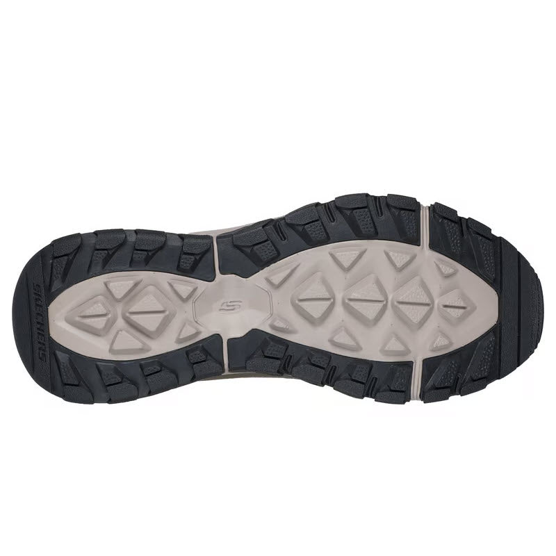 The image shows the sole of the SKECHERS DYNAMITE AT ESCAPAR SLIP INS TAUPE - MENS, featuring a rugged, textured tread in light gray and black with triangular lugs and grooves for optimal traction and stability on varied terrain.
