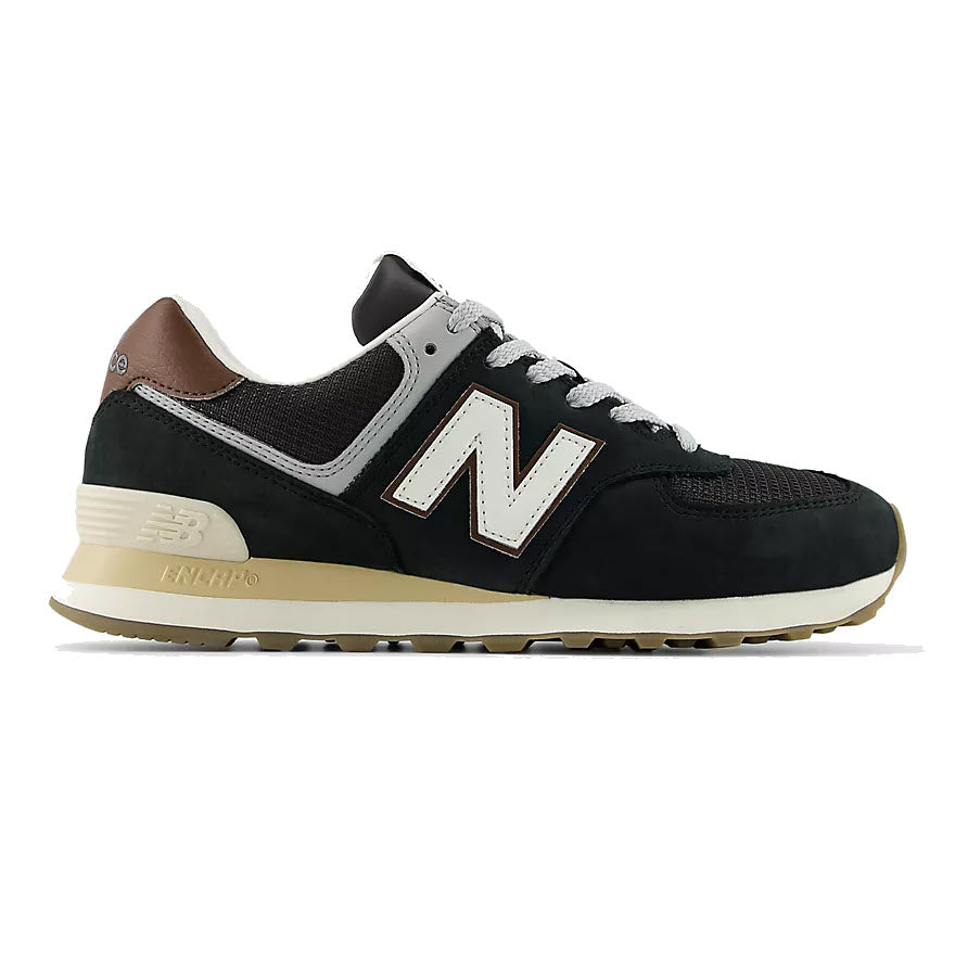 A black New Balance sneaker with white and beige accents, featuring a large white N logo on the side, brown patch on the heel, and a beige and brown rubber sole.
