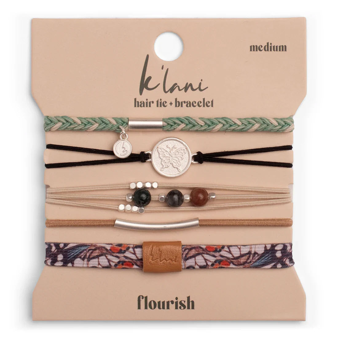 A set of five assorted hair ties and bracelets displayed on a branded card. The designs include braided, beaded, and patterned bands in earth tones, with charm and metallic accents. The card reads “k’lani hair tie + bracelet, medium, flourish.”.