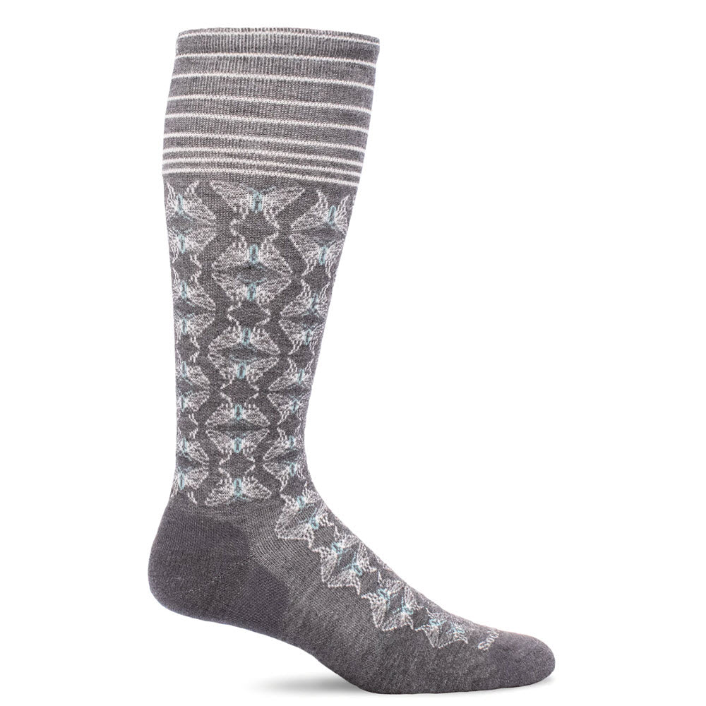 A single knee-high grey sock with light blue and white geometric patterns and horizontal stripes at the top. The design features a mix of zigzag and star-like shapes.