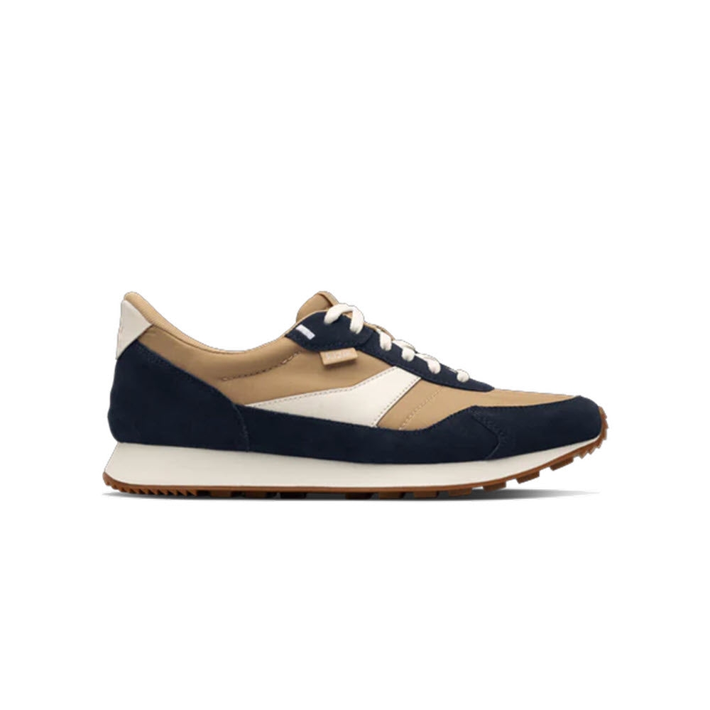 A casual sneaker with a navy blue, beige, and white color scheme, featuring white laces, a white midsole, and a brown rubber outsole, shown in a side profile view.
