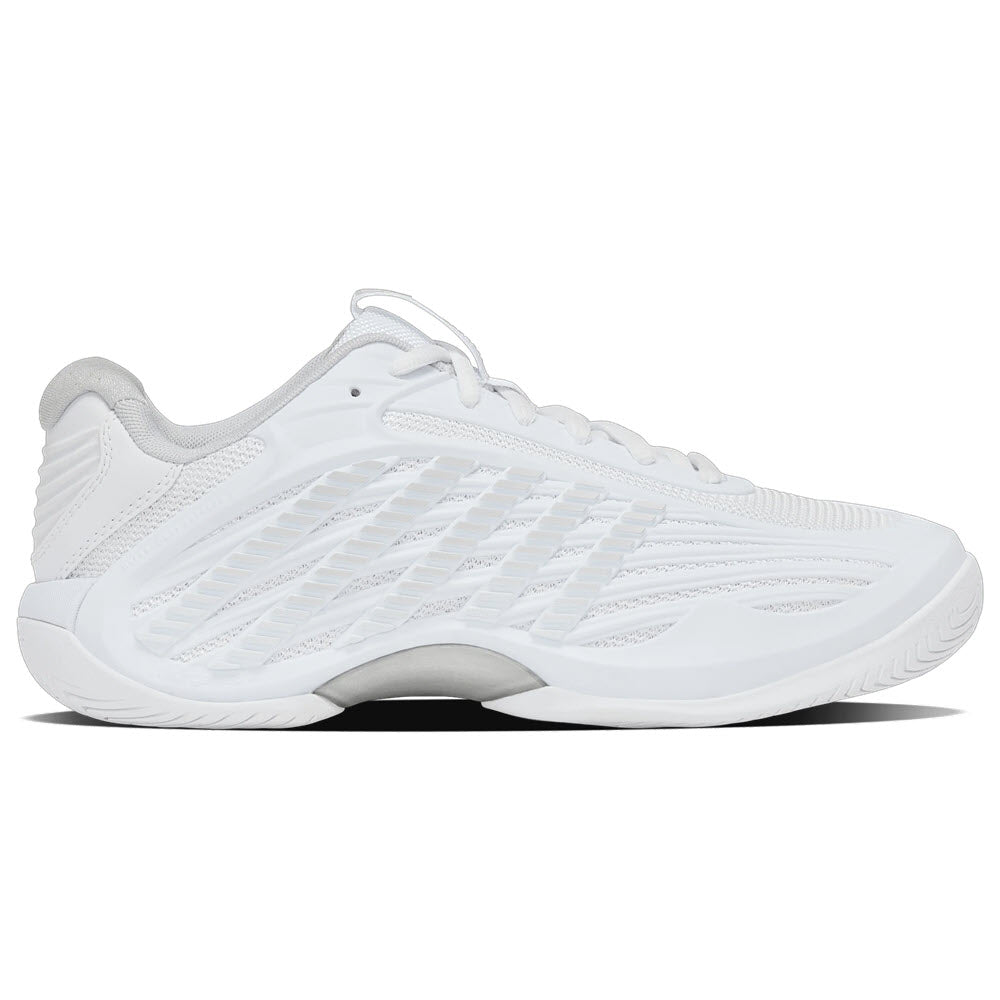 A side view of a white athletic sneaker with a textured sole, mesh and synthetic upper, and subtle gray accents on the heel and sole.