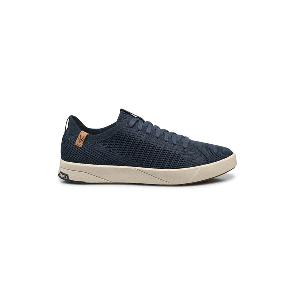A navy blue mesh sneaker with a beige rubber sole, navy laces, and a small tan leather accent near the heel, shown in a side profile on a white background.
