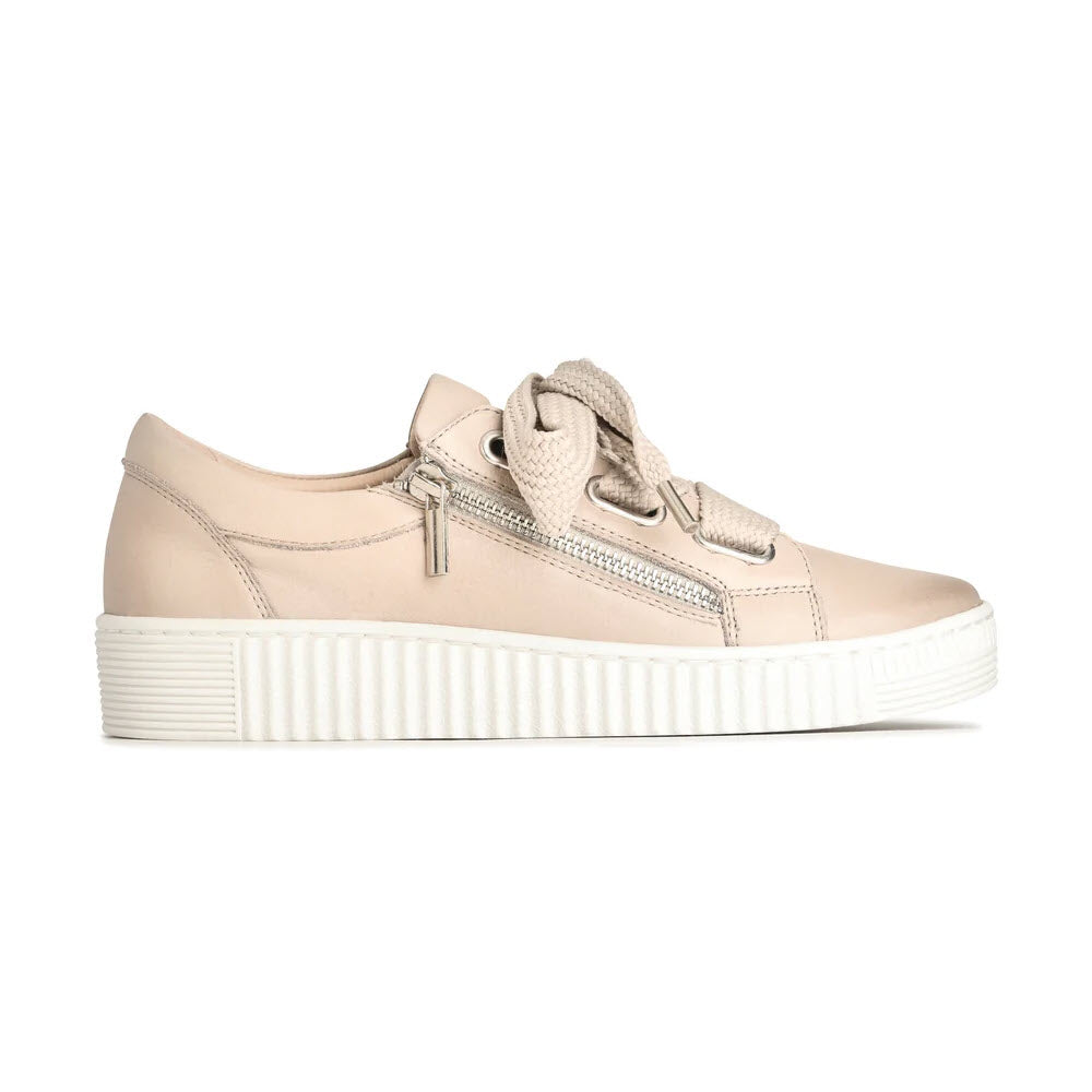 Beige leather sneaker with a thick white sole, chunky beige laces, and a silver side zipper detail, shown in a side profile on a white background.