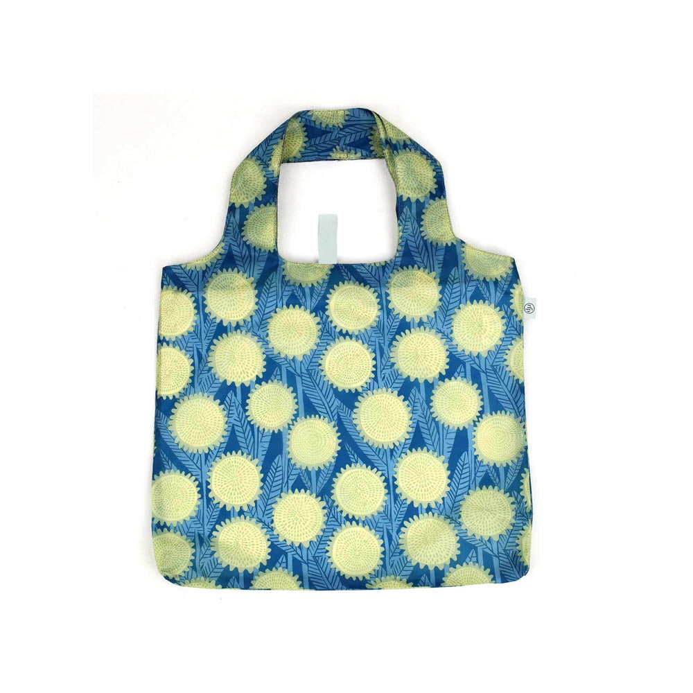 Reusable tote bag with short handles, featuring a pattern of yellow sunflowers and green leaves on a blue background. The bag is displayed against a white backdrop.