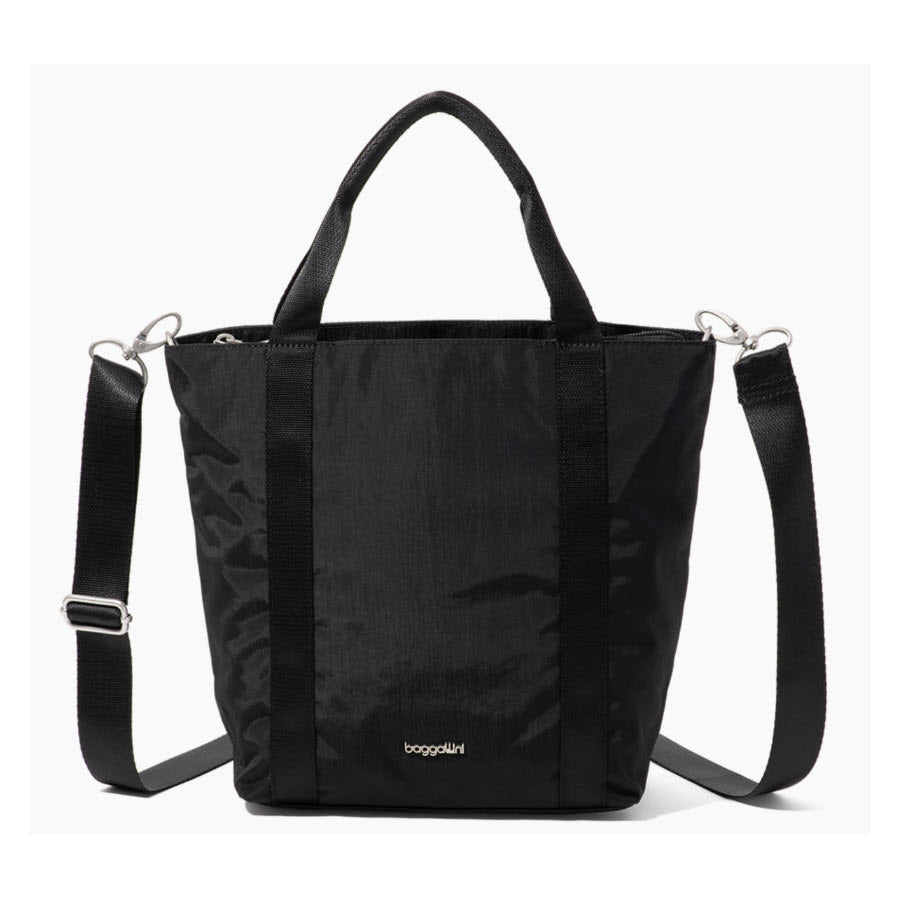 A black tote bag with short handles and a detachable, adjustable shoulder strap, featuring the brand name baggallini in small gold letters near the bottom.