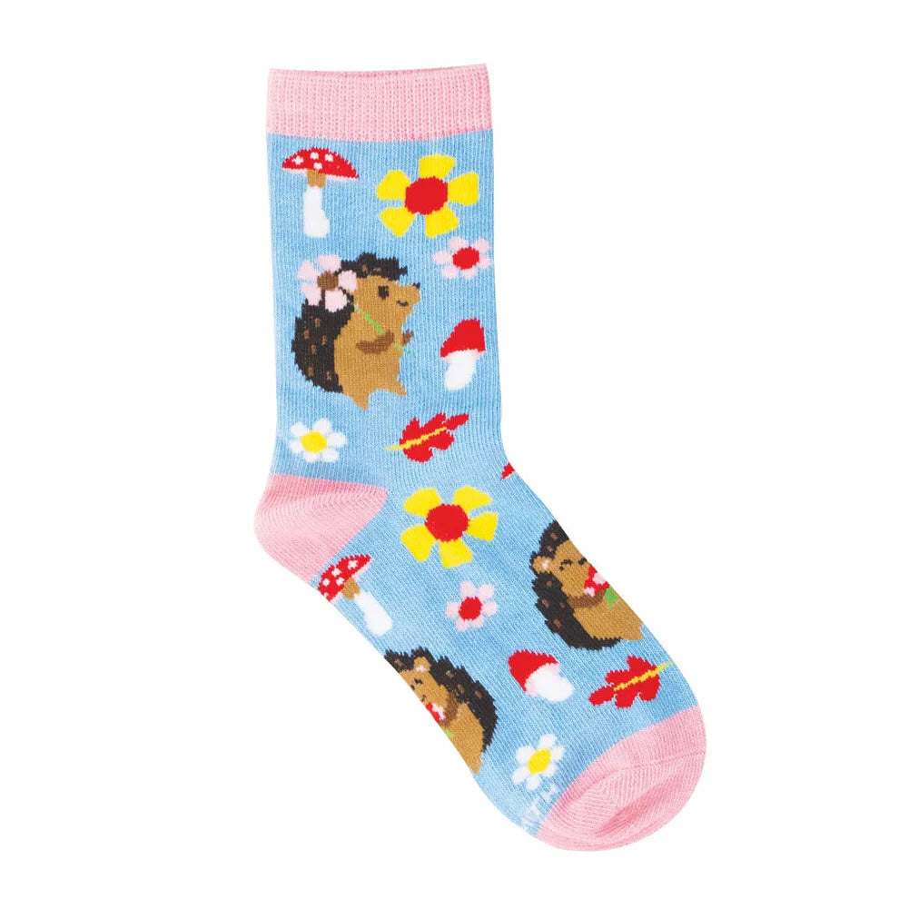 A light blue sock with pink accents, decorated with cartoon hedgehogs, yellow flowers, and red-and-white mushrooms.