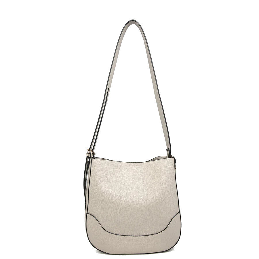 A minimalist, light beige shoulder bag with a curved bottom, black edge detailing, and a long adjustable strap, displayed on a plain white background.
