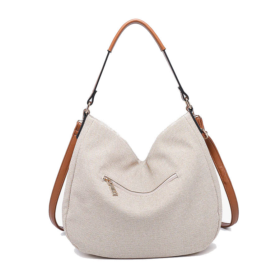 A large slouchy beige hobo bag with a brown leather top handle and side straps, featuring a small front zipper pocket.