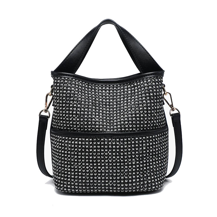 A black and white patterned bucket bag with black leather handles and a detachable shoulder strap, featuring metallic hardware and a textured woven design.