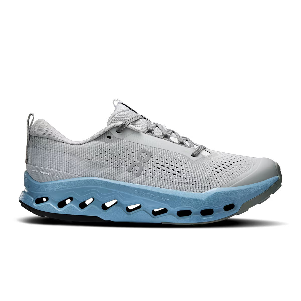 A light grey athletic running shoe with a blue cushioned sole featuring large cut-out holes. The shoe has a mesh upper, lace-up design, and ON logo on the side. The overall look is modern and sporty.