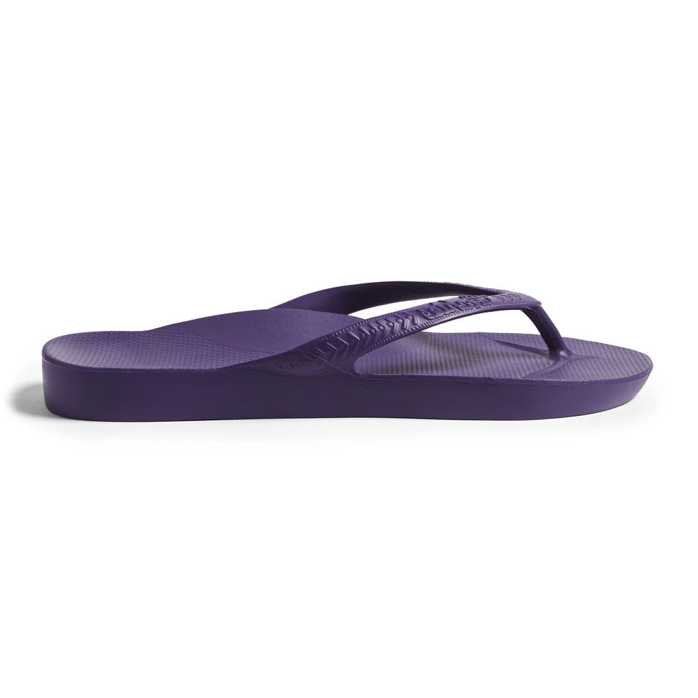 A single purple flip-flop sandal with a textured footbed and simple thong strap, shown in a side profile on a white background.