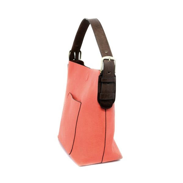 Coral-pink vegan leather Joy Susan Hobo Tango Coral shoulder bag with a dark brown adjustable strap and external pocket detail, against a white background.