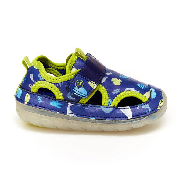 Children's colorful Stride Rite SM Splash Blue Multi sneaker with dinosaur print on white background.