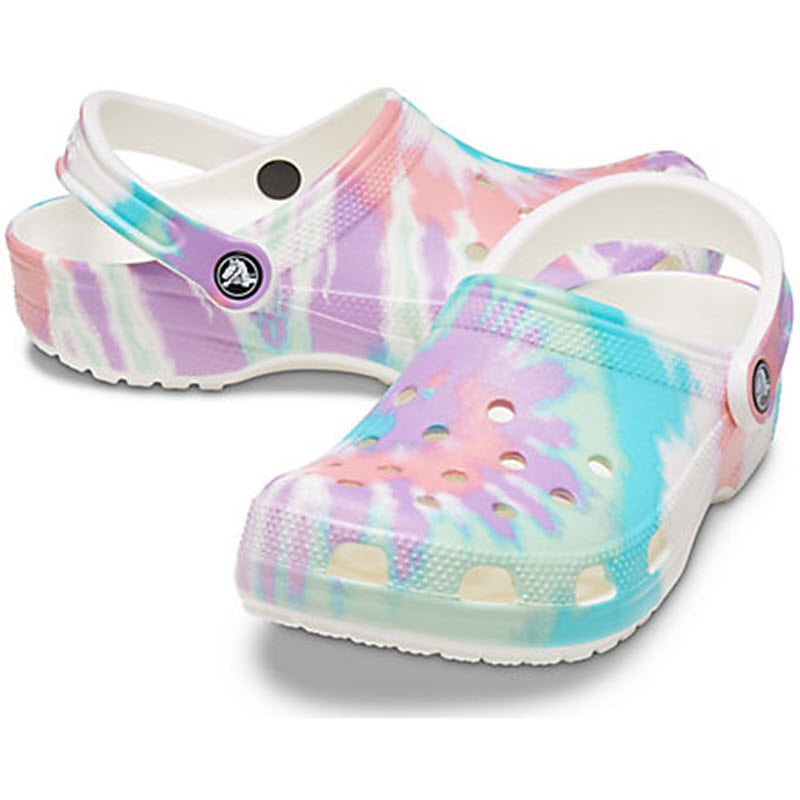 A pair of colorful tie-dye patterned Crocs Classic Clog with a back strap, perfect as a kid&#39;s shoe.