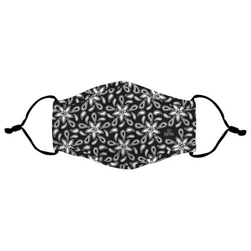 A Karma face mask in black polyester with a white floral pattern and adjustable ear loops, isolated on a white background.