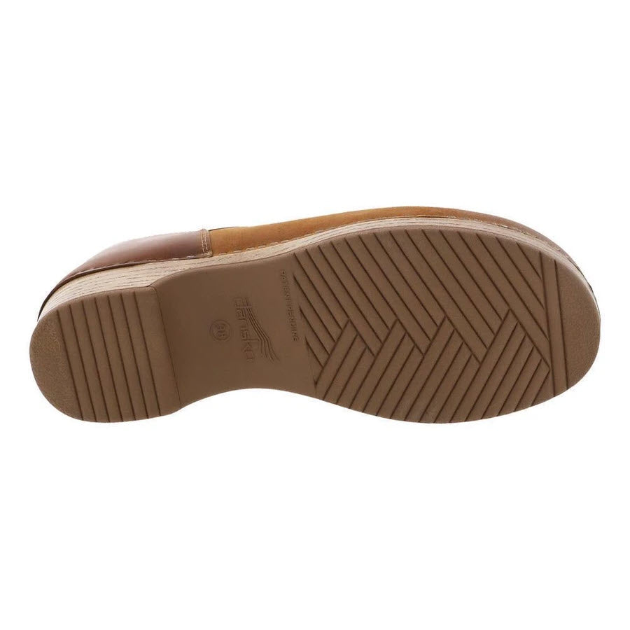Sole of a Dansko Brenna Tan Burnished Suede slip-on shoe with herringbone tread pattern.