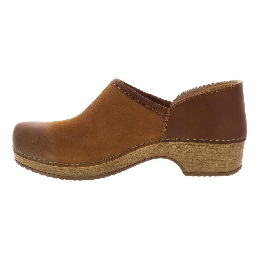 Side view of a brown Dansko Brenna Tan Burnished Suede slip-on shoe with wooden sole.