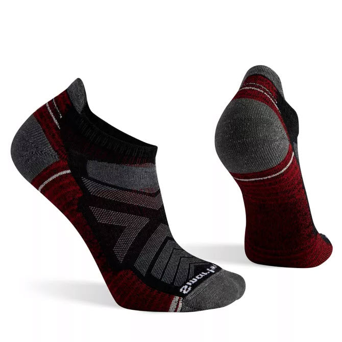 Pair of ankle-length Smartwool Hike Light Low Men&#39;s Charcoal socks with a red and gray color scheme displayed against a white background.
