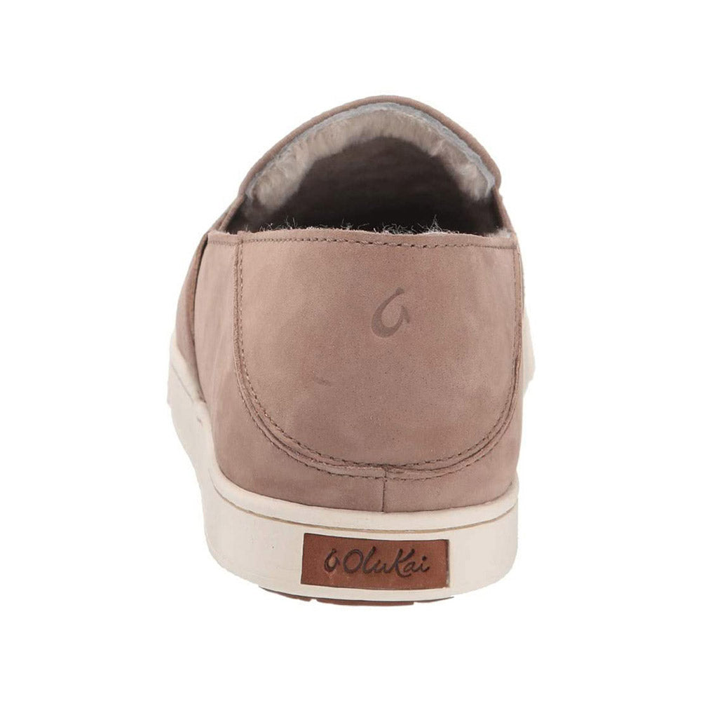 Rear view of a beige waterproof nubuck leather shoe with a logo on the upper heel and an Olukai Pehuea Heu Taupe Grey/Taupe Grey branded label on the lower heel.