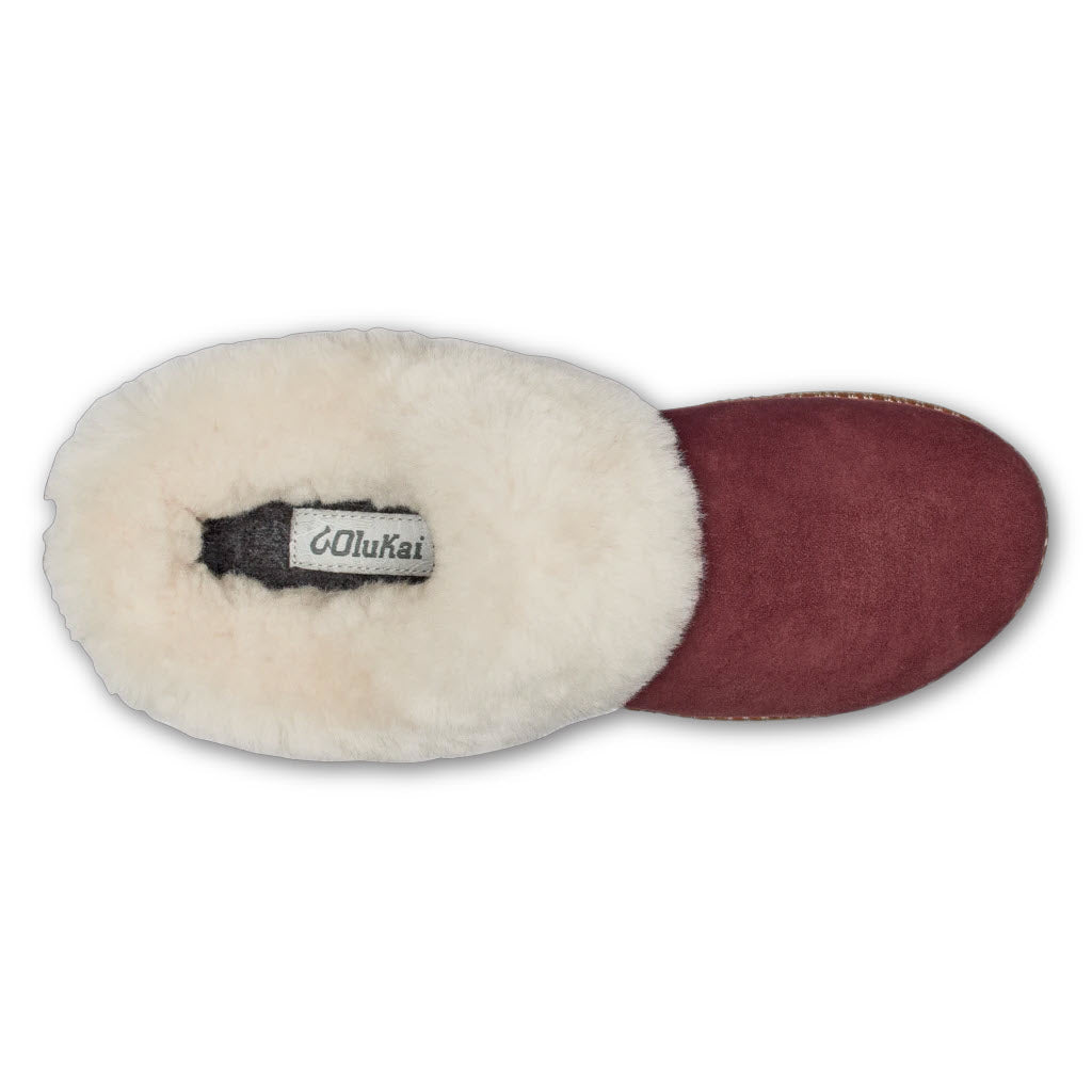 A single Olukai kui slipper with a plush, shearling-lined interior and a maroon exterior.