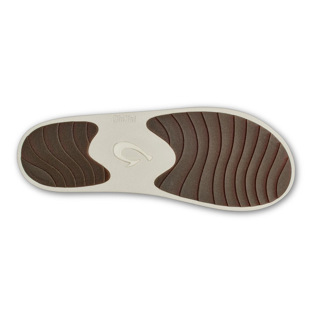 Sole of an OluKai Ku&#39;i Canoe/Tan slipper with brown treads and a logo in the center.