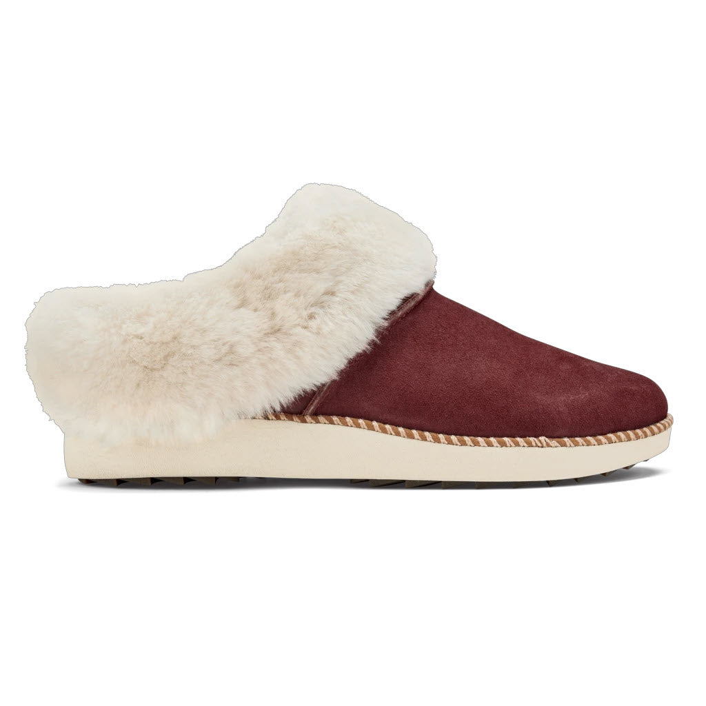 A burgundy suede Olukai Kui Canoe/Tan slipper with fluffy white shearling-lined and a rubber sole for maximum comfort.