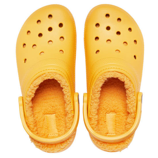 A pair of yellow Crocs Classic Lined Clog Orange Sorbet with warm lining, available in women&#39;s sizes.