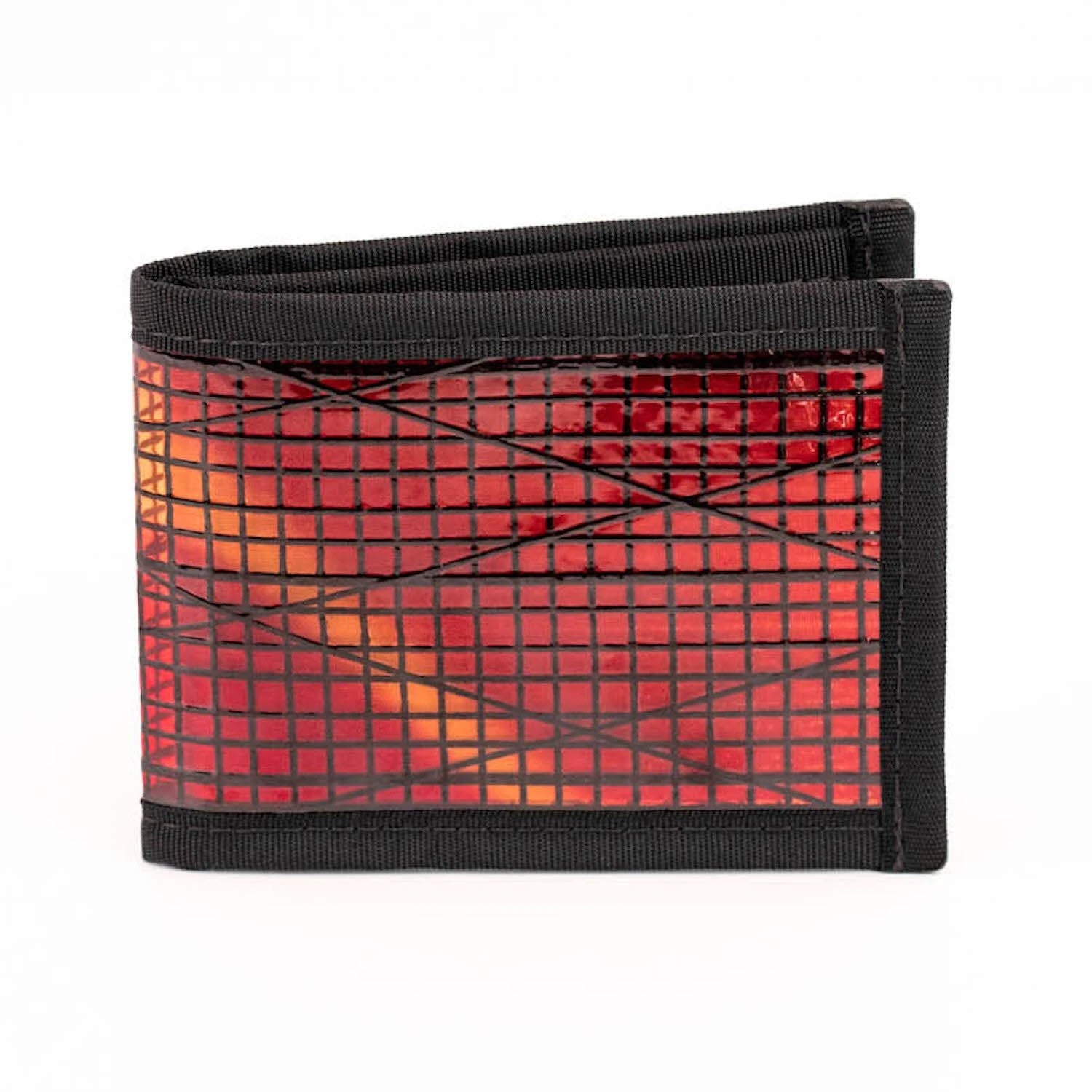 A Flowfold Vanguard Sunset Sailcloth wallet made from recycled sailcloth fabric in black and red, featuring a checkered design, photographed against a white background.