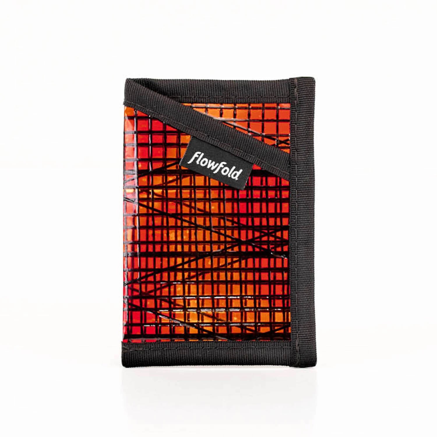 A red and black Flowfold Minimalist Sunset sailcloth wallet, made from recycled racing sails, against a white background.