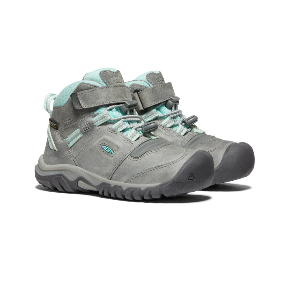 A pair of Keen Ridge Flex Mid Child Grey/Blue Tint - Kids women&#39;s hiking boots with pull-cinch closure and rugged soles.