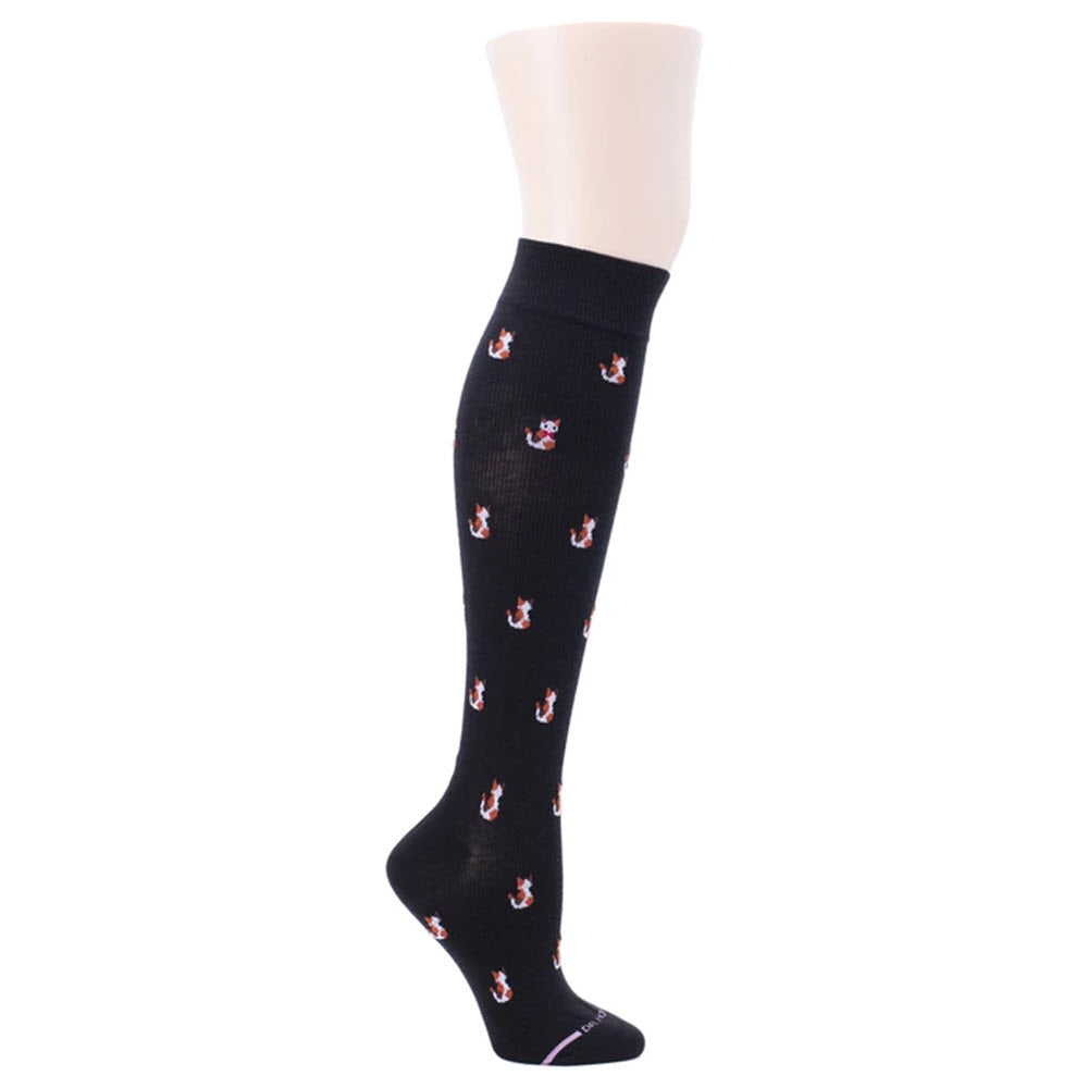 A mannequin leg wearing a Dr. Motion black knee-high compression sock with anchor patterns, designed to enhance blood flow.