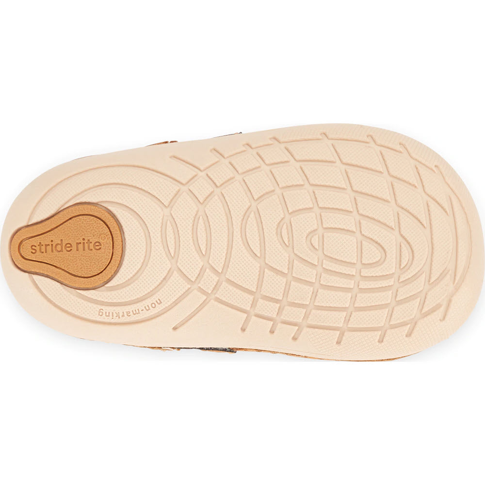 The sole of a child&#39;s Stride Rite Soft Motion Lucianne Honey Tan toddler shoe with a tan tread pattern and a &quot;Stride Rite&quot; logo visible.