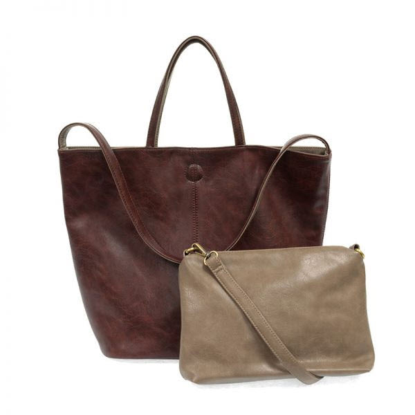 A large brown Joy Susan Renee Reversible Tote Bag made of vegan leather and a small beige crossbody bag featuring a boho print against a white background.