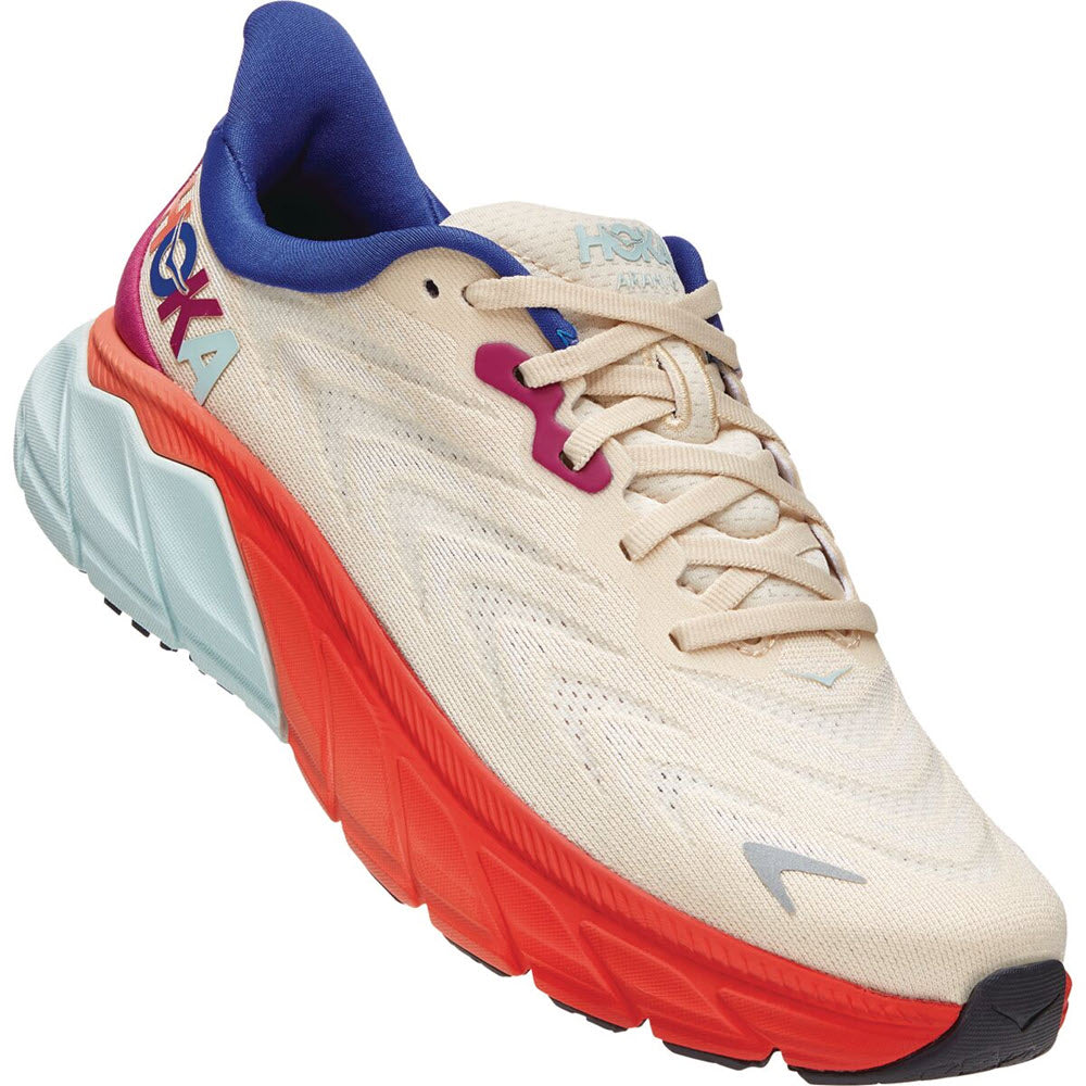 A side view of a two-toned HOKA ARAHI 6 SHORT BREAD/FIESTA running shoe with a beige upper and a contrasting red sole.