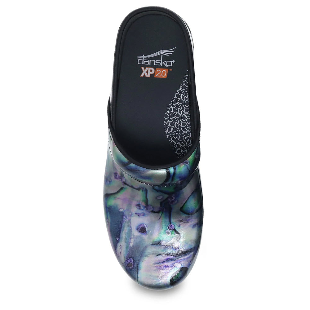 Top view of a single, multicolored clog shoe with a black insole labeled &quot;Dansko Pro XP 2.0,&quot; featuring Dansko Natural Arch technology.