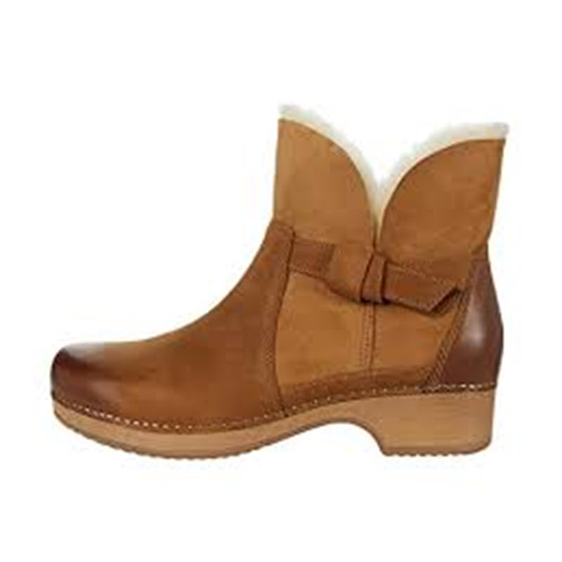A Dansko Bessie Honey Burnished ankle boot with a white fur lining, leather uppers, and a low heel.