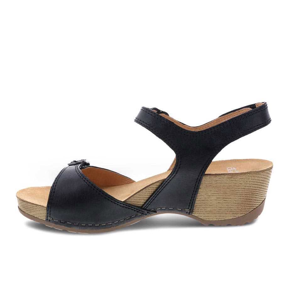 Dansko black women&#39;s open toe wedge sandal on a white background.
