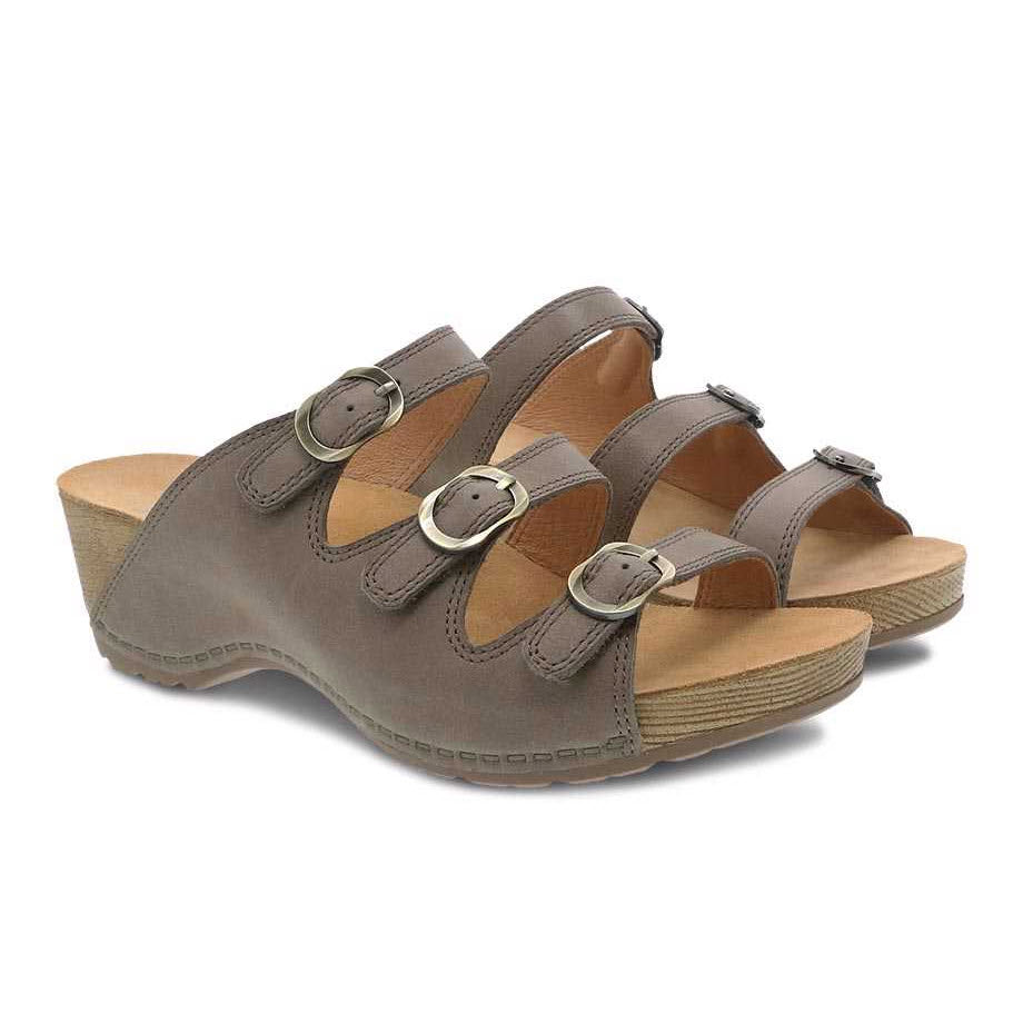 A pair of gray three-strap Dansko Tarin Taupe Burnished Nubuck sandals with adjustable forefoot straps on a white background.