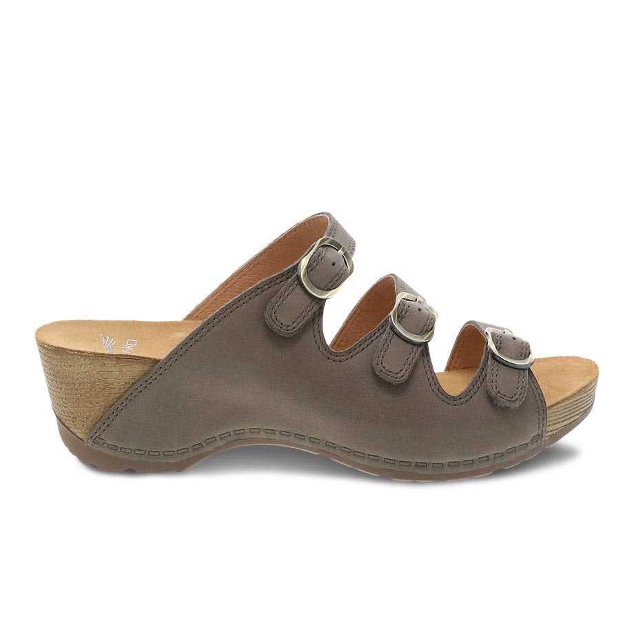 Brown Dansko Tarin Taupe Burnished Nubuck sandal with a cork sole on a white background.