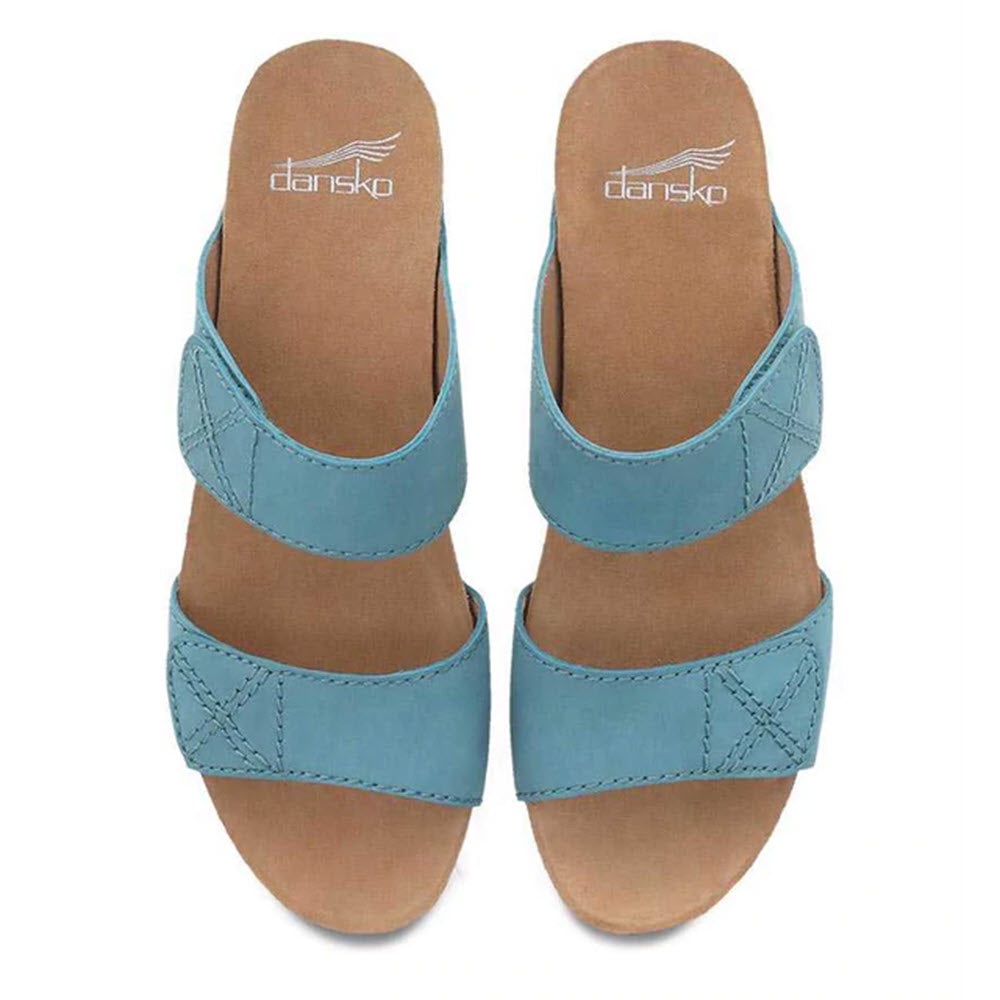 A pair of blue Dansko Maddy Lagoon Milled Nubuck slide sandals with leather uppers displayed from a top-down view.