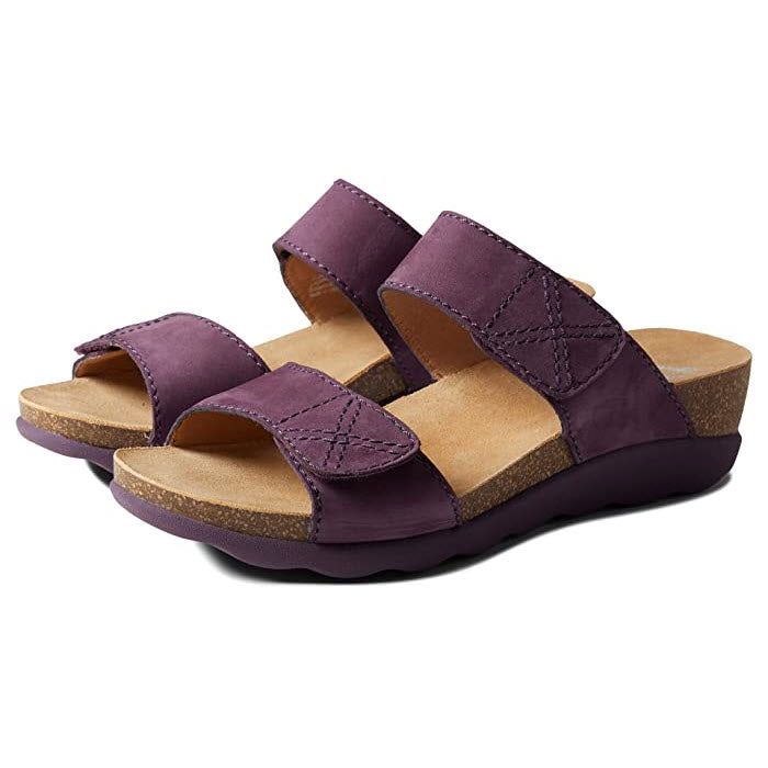 A pair of Dansko Maddy Purple Nubuck slide sandals with a lightweight cork midsole and rubber sole.