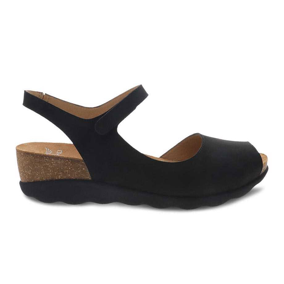 Black Dansko Marcy Wedge sandal with ankle strap on a white background.