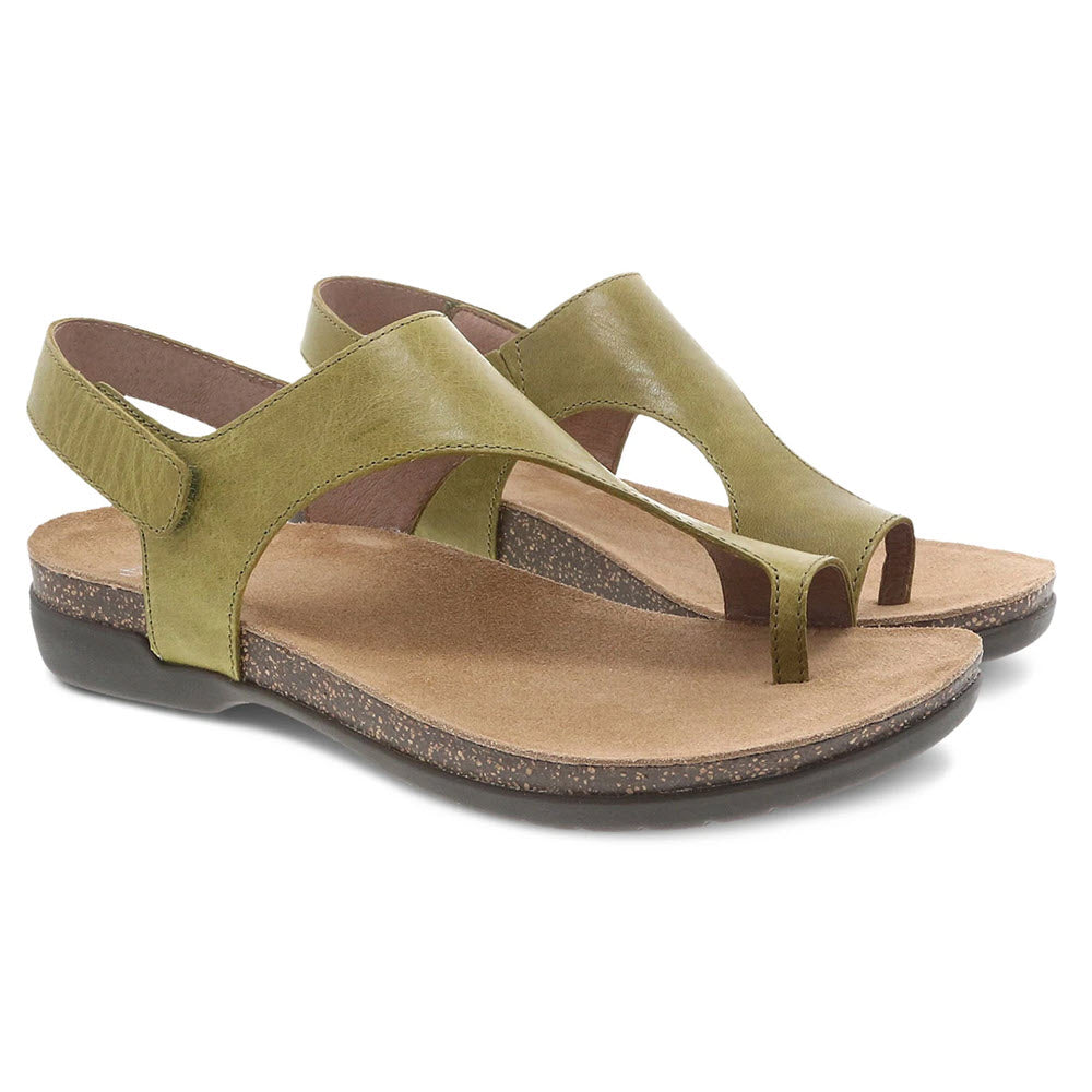 A pair of green Dansko Reece Cactus Waxy Burnished leather sandals with adjustable back strap and hook-and-loop straps on a white background.
