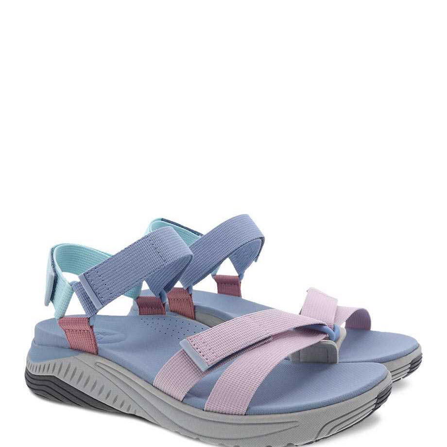 A pair of blue and pink Dansko Racquel Sky Multi Webbing summer sandals with adjustable straps on a white background.