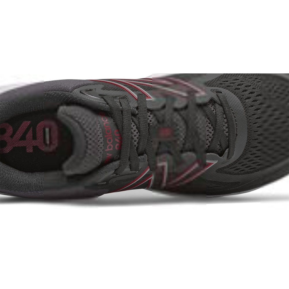Close-up of a men&#39;s New Balance 840V5 BLACK/HORIZON athletic shoe with red accents and laces.