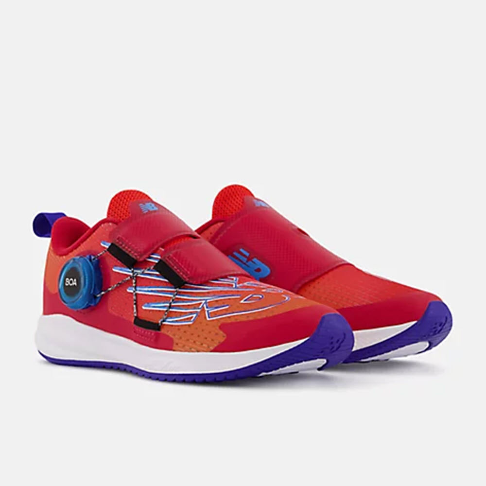A pair of New Balance FuelCore Reveal Neo Flame children&#39;s running shoes with elastic laces, a loop on the heel, and REVlite midsole technology.