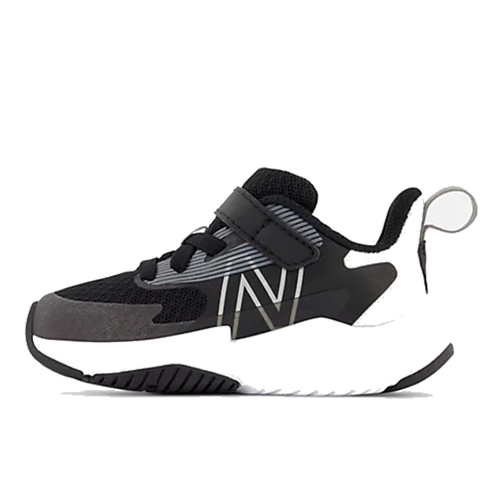 A black and white New Balance Rave Run V2 athletic kids’ running shoe with a strap closure, a loop on the heel, and a breathable mesh upper.