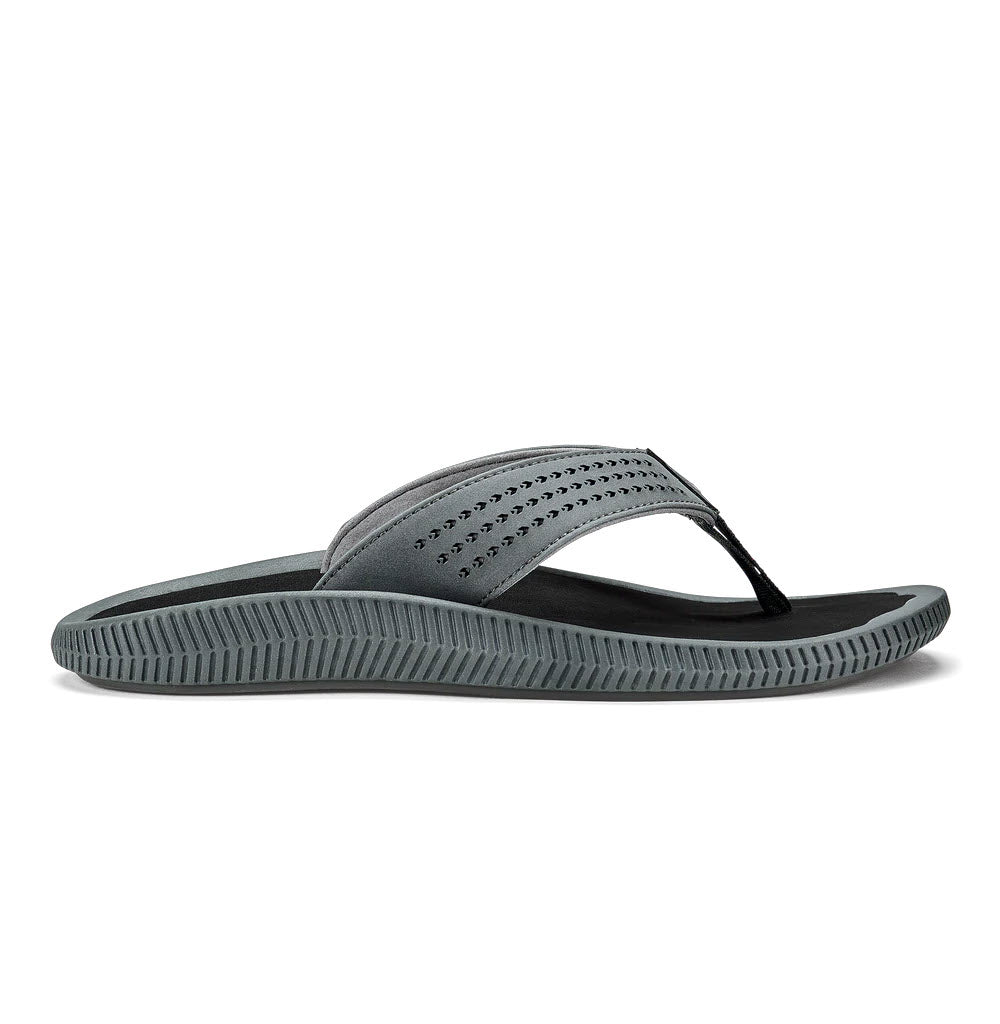 Side view of a single gray Olukai Ulele Dark Shadow - Mens water-friendly sandal on a white background.